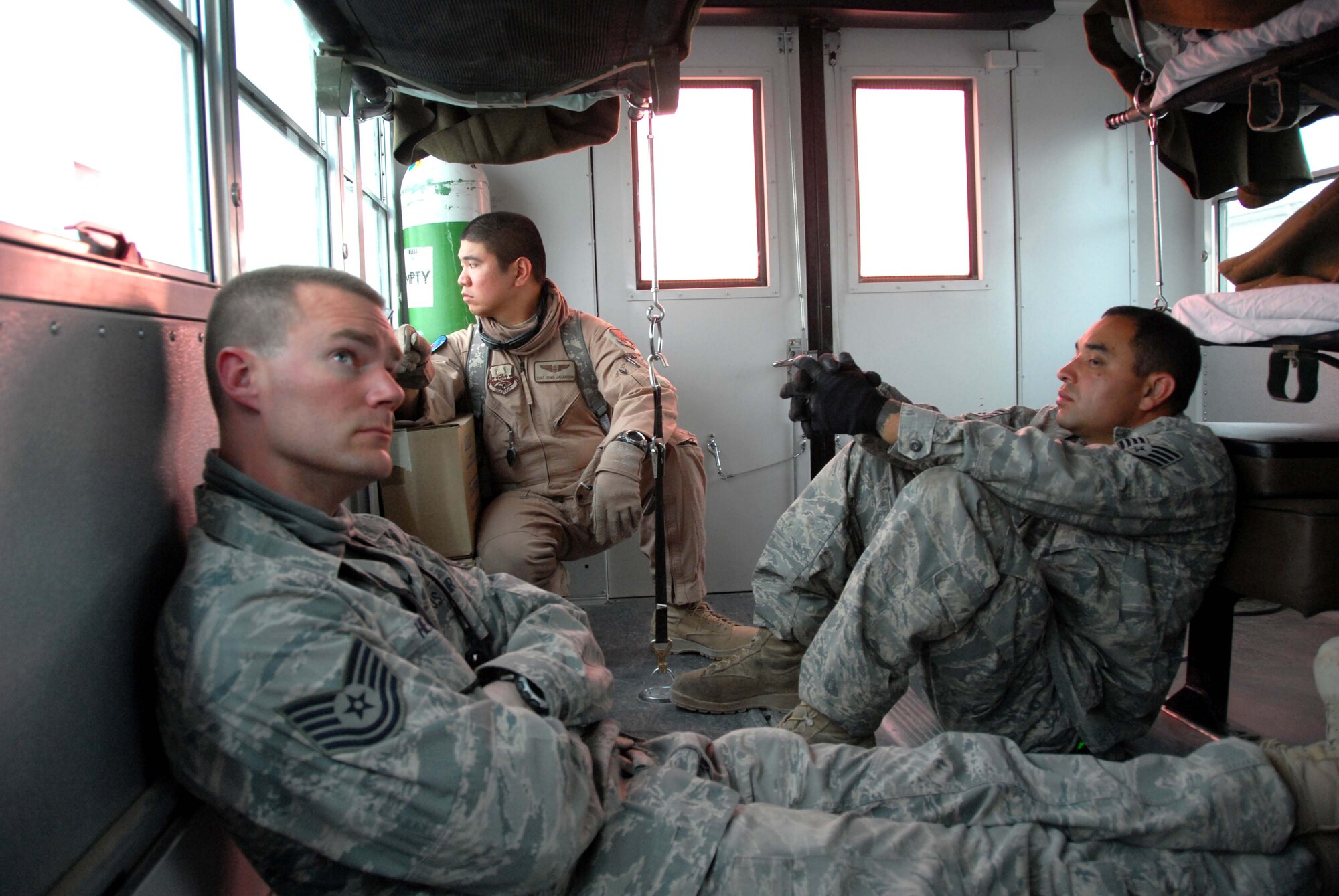 Technical Sgt. Michael Hendrix, Staff Sgt. Sean Jaladoni, and Staff Sgt. Manolito Ruiz wait on a bus to load CASF patients on to a C-130 at Kandahar Airfield, Afghanistan March 27th. Hendrix and Ruiz are volunteers who work with patients. 