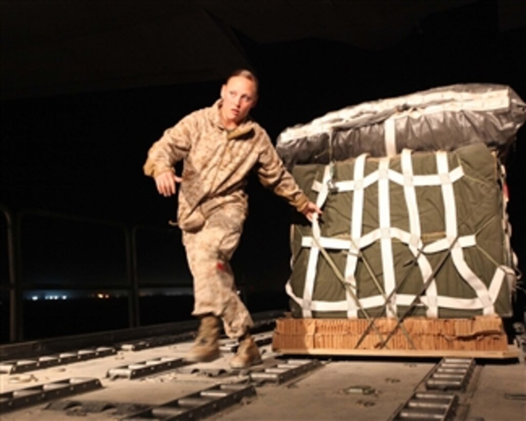 U.S. Marine Corps Cpl. Sherri A. Townsend, an air delivery specialist with Air Delivery Platoon, 2nd Marine Logistics Group, pulls a container of food and water down the ramp of a C-130 Hercules aircraft at Camp Bastion, Helmand province, Afghanistan, on March 20, 2011.  The 2nd Marine Logistics Group worked alongside the 2nd Marine Aircraft Wing to deliver supplies in support of International Security Assistance Force operations.  