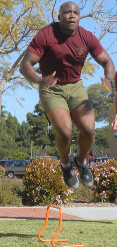 Sgt. Omar B. Askew, a student from Career Planners Course, jumps over small hurdles before doing leg and ammo can lifts during a high-intensity workout April 1.