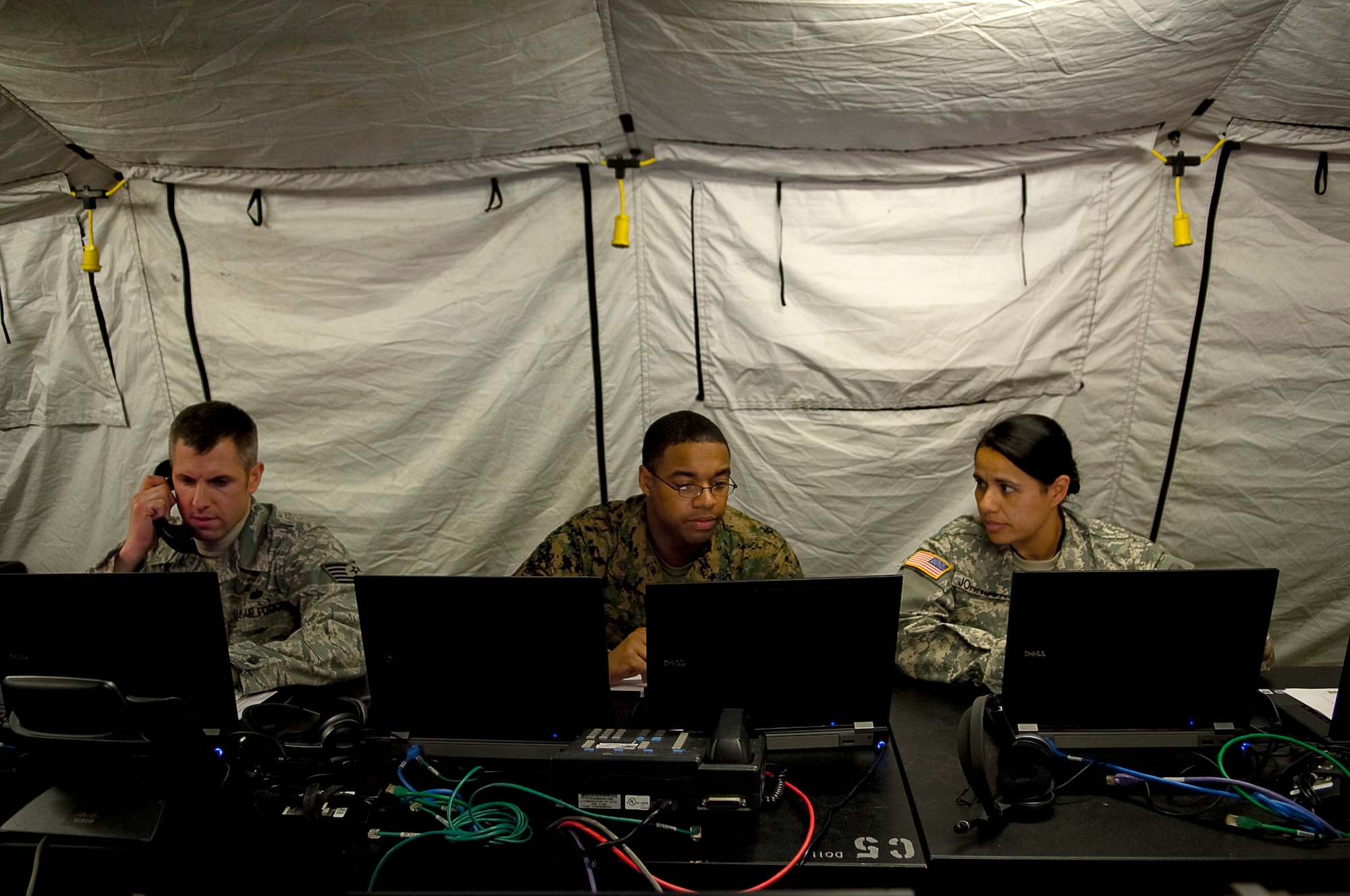 YOKOTA AIR BASE, Japan -- U.S. Air Force Tech. Sgt Davis Way, Marine Sgt. Terrall Miller, and Army Specialists Sonya Johnson, Joint Communication Support Element, work on the communicators equipment in the Deployable Joint Command and Control System (DJC2) at Yokota Air Base April 1. The DJC2 is deployed to Yokota to provide communications in support of Operation Tomodachi (U.S. Air Force photo/Master Sgt. Jeromy K. Cross)














