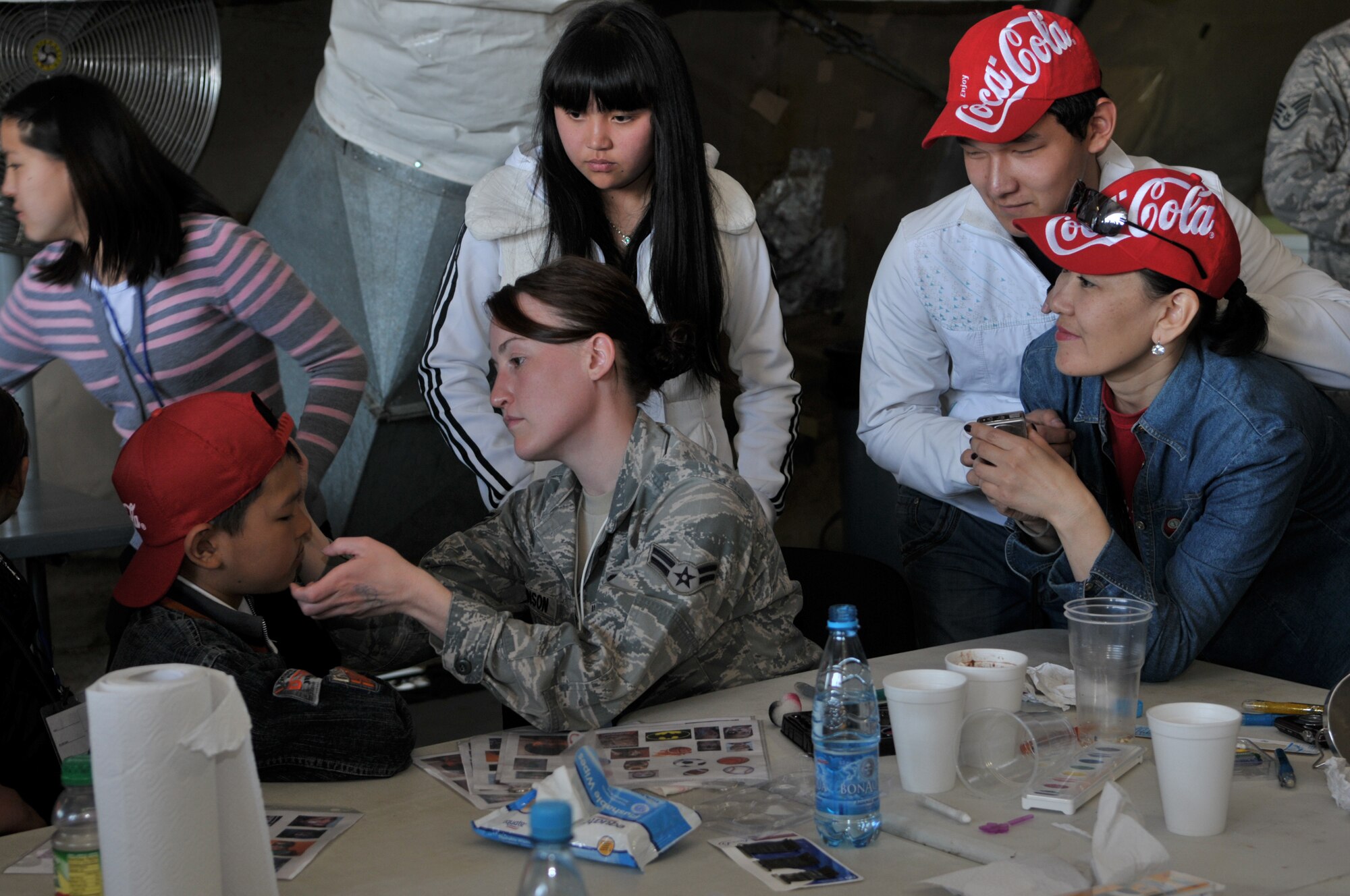 TRANSIT CENTER AT MANAS, Kyrgyzstan - Children have their faces painted during the festivities at the Transit Center at Manas Apr. 02.  The Transit Center held a friends and family day that included a barbeque, music, games, K-9 demonstration, and Explosive Ordnance Disposal demonstration. (U.S. Air Force photo/Staff Sgt. Stacy Moless)