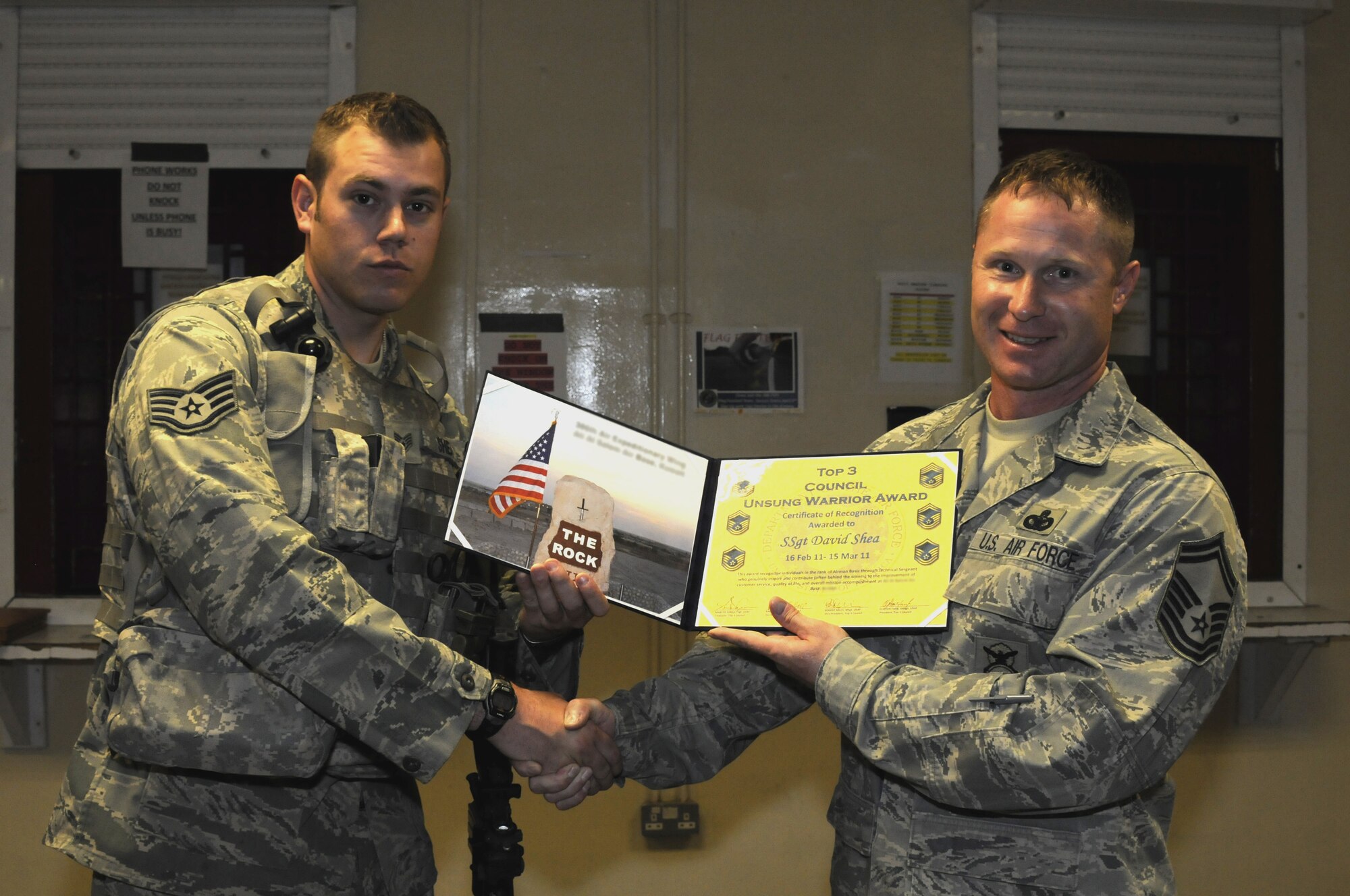Staff Sgt. David Shea of the 386th Expeditionary Security Forces Squadron, left, is presented the 386th Top III's Unsung Warrior award by Senior Master Sgt. Clifton Farr April 2 at The Ranch. (U.S. Air Force photo by Capt. Heath Allen)
