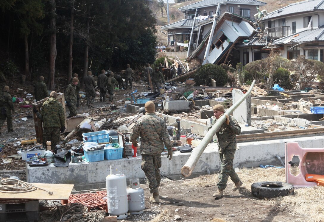 Marines with Battalion Landing Team, 2d Battalion, 5th Marines, 31st Marine Expeditionary Unit, remove debris from among severely damaged homes here during Operation Field Day, a clearing and cleanup project designed to open harbor access and area roads on the isolated island.  As Marines cleared the area, they took time to locate personal items which could be salvaged by the local residents.  The 31st MEU is participating in Operation Tomodachi at the request of the Japanese government after the 9.0 earthquake and tsunami devastated the northeast coast of Japan.