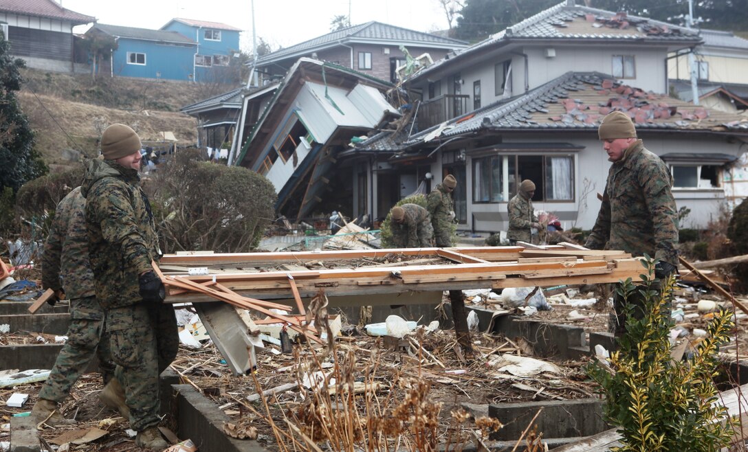 Marines with Battalion Landing Team, 2d Battalion, 5th Marines, 31st Marine Expeditionary Unit, remove debris from among severely damaged homes here during Operation Field Day, a clearing and cleanup project designed to open harbor access and area roads on the isolated island.  As Marines cleared the area, they took time to locate personal items which could be salvaged by the local residents.  The 31st MEU is participating in Operation Tomodachi at the request of the Japanese government after the 9.0 earthquake and tsunami devastated the northeast coast of Japan.