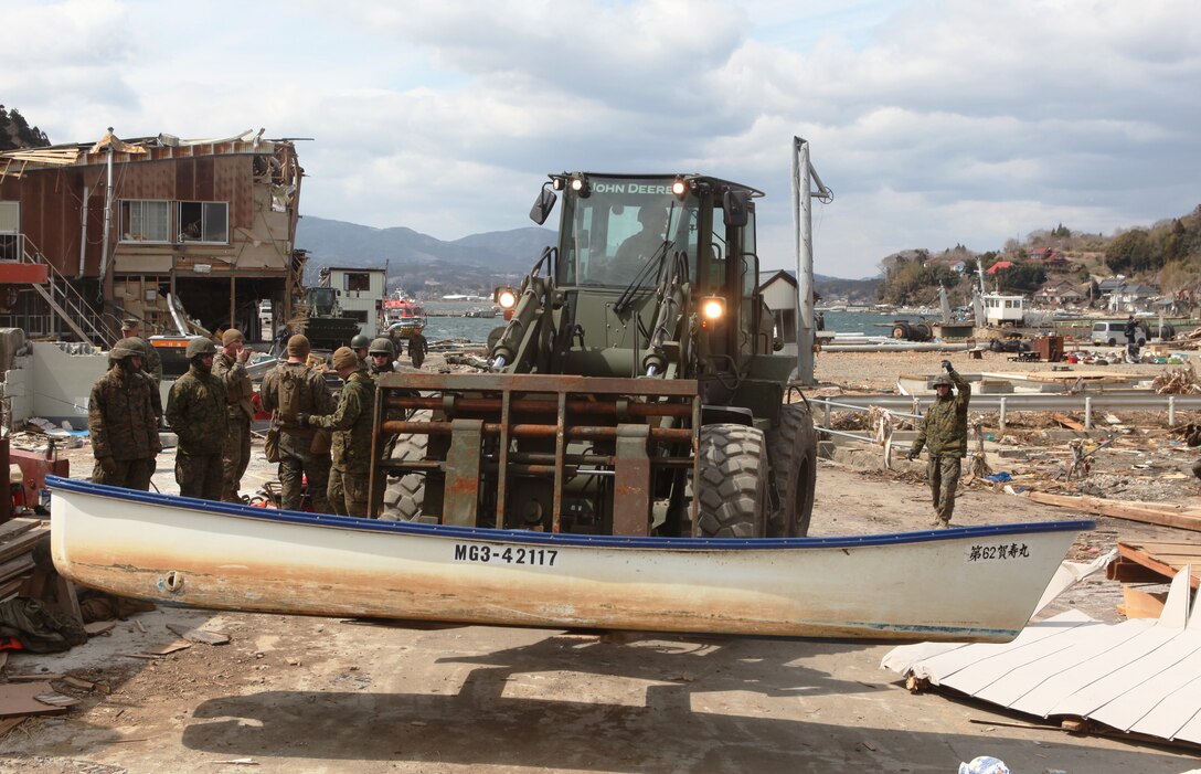 Marines with the 31st Marine Expeditionary Unit use heavy equipment to move a local fisherman’s undamaged boat to the harbor area, allowing him to start to rebuild his way of life.  Marines are participating in Operation Field Day, a clearing and cleanup project designed to open harbor access and area roads on the isolated island.  As Marines cleared the area, they took time to locate personal items which could be salvaged by the local residents.  The 31st MEU is participating in Operation Tomodachi at the request of the Japanese government after the 9.0 earthquake and tsunami devastated the northeast coast of Japan.