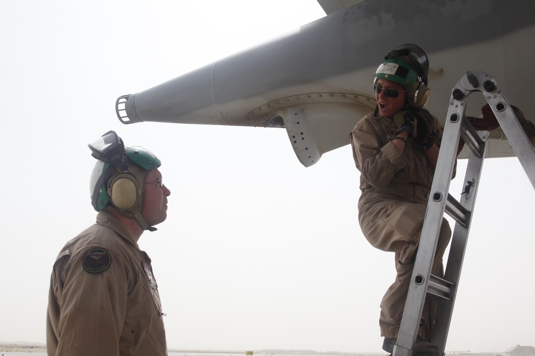 Cpl. Erin C. Pesti takes instruction from Staff Sgt. Jacob A. Cobb while she performs maintenance checks on a KC-130J Hercules, April 3. Pesti, an Athens, Ga., native and KC-130J crew chief with Marine Aerial Refueler Transport Squadron 152, is currently serving her fifth month deployed to Kandahar Air Field, Afghanistan, where her squadron supports 2nd Marine Aircraft Wing (Forward).