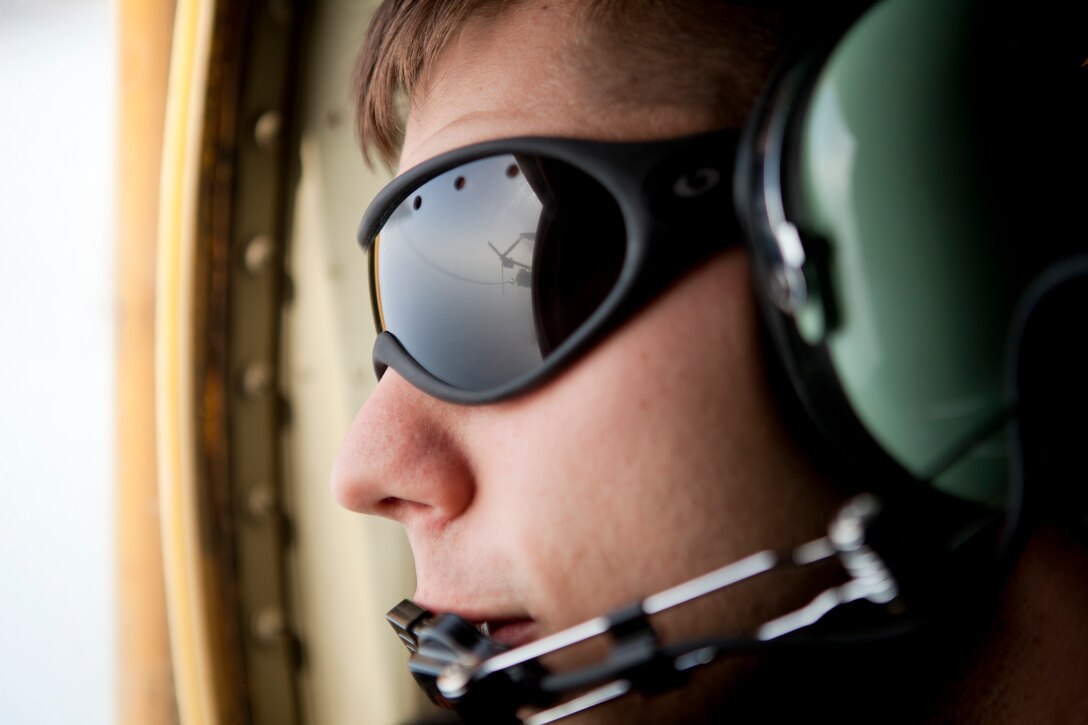 Lance Cpl. Hudson Baugh, a KC-130J loadmaster with Marine Aerial Refueler Transport Squadron 252, peers out the window of a KC-130J Hercules while a MV-22B Osprey with Marine Medium Tiltrotor Squadron 266 refuels, mid-flight, on the way to Naval Support Activity Souda Bay, Greece, April 3. Marines planned and coordinated for more than one month in preparation for mission to return VMM-266 to the USS Kearsarge, 26th Marine Expeditionary Unit, after a deployment in support of operations in Afghanistan.