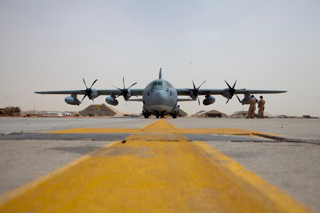Marines with 2nd Marine Aircraft Wing (Forward) mingle while a KC-130J Hercules, with Marine Aerial Refueler Transport Squadron 252, is refueled, April 3. VMGR-252 stopped in Kuwait to refuel during a 15-hour flight from Camp Bastion, Afghanistan to Naval Support Activity Souda Bay, Greece, while escorting three MV-22B Ospreys with Marine Medium Tiltrotor Squadron 266 to the USS Kearsarge, 26th Marine Expeditionary Unit, after a deployment in support of operations in Afghanistan.
