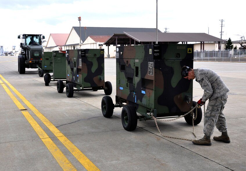 Senior Airman Ryan Tiner, 621st Contingency Response Wing aerial porter assigned to Joint Base McGuire-Dix-Lakehurst, N.J., prepares a power generator to be loaded onboard a U.S. Air Force C-17 Globemaster III assigned to JB Pearl Harbor-Hickam, Hawaii, at the Misawa Air Base, Japan flightline April 2, 2011. The aircraft, flown by members of the 517th Airlift Squadron assigned to Joint Base Elmendorf-Richardson, Alaska, took the generators to Yokota Air Base, Japan, in support of Operation Tomodachi. (U.S. Air Force photo/Senior Airman Joe McFadden)
