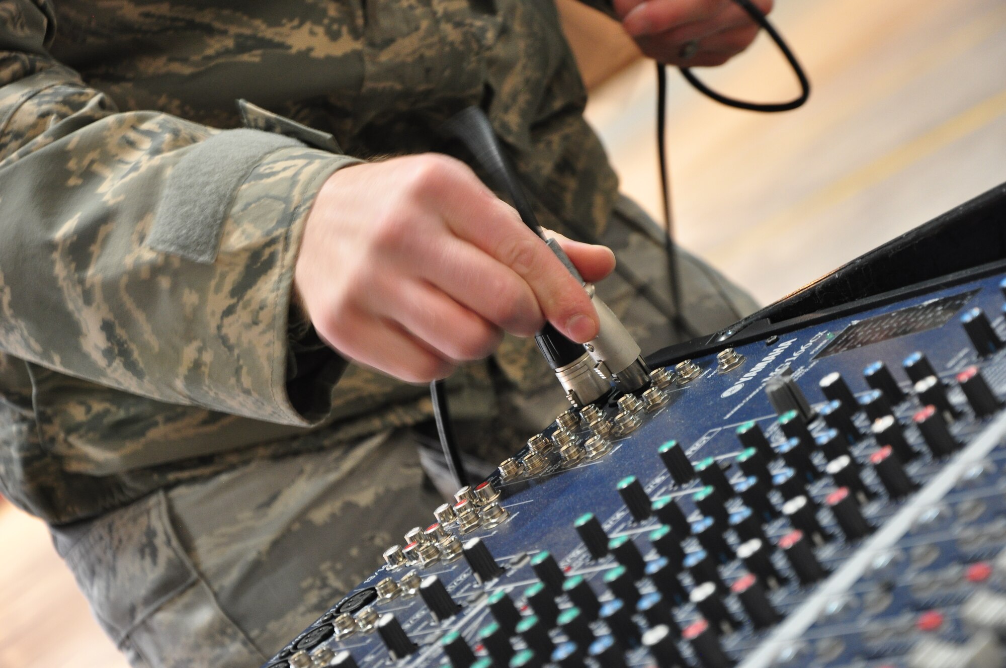 An Airman with the 51st Communications Squadron hooks up some audio equipment for a commander's call here March 25. The 51st CS proved it was one of the best squadrons in the Air Force in 2010 by winning several major command-level Air Force awards. (U.S. Air Force photo/Staff Sgt. Chad Thompson)