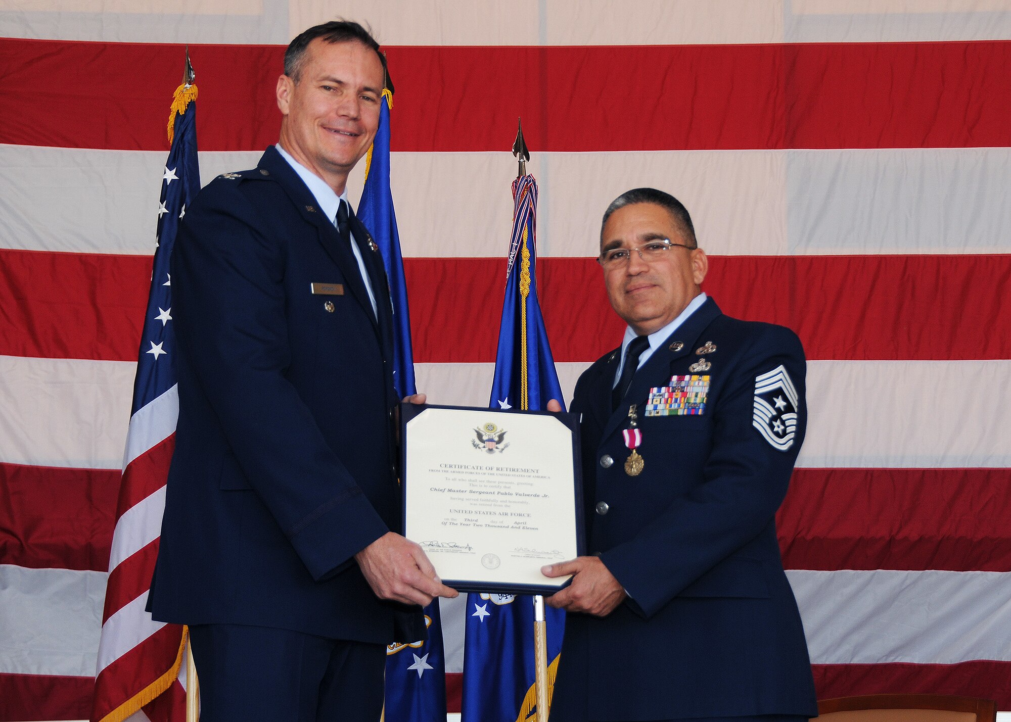 Chief Master Sgt. Pablo Valverde Jr., 944th Fighter Wing command chief, receives his Certificate of Retirement from Colonel Michael G. Popovich, presiding officer, April 3 during his retirement ceremony at Luke Air Force Base, Ariz.  (U.S. Air Force photo/Staff Sgt. Louis Vega Jr.)