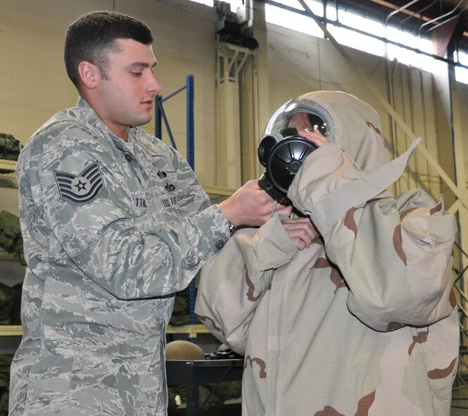 Tech. Sgt. Justin Shattuck, 446th Civil Engineering Squadron emergency manager, helps Carmen Cook, a director with the Washington State Employment Security Department here, don a chemical warfare protective suit during the 446th Airlift Wing's Employer Orientation Day at McChord Field, April 2.  Civilian employers spent the day learning about the Reserve mission with a mock mobility line and orientation flight aboard a C-17 Globemaster III. (U.S. Air Force photo by Staff Sgt. Elizabeth Moody)