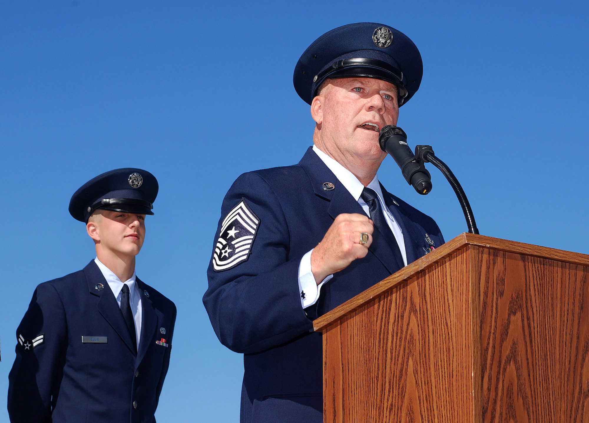 Chief Master Sgt John M. Anderson, 94th Airlift Wing Command Chief, speaks to the Wing on the day of his retirement, after 33 years of active and reserve Air Force duty, Apr 3.  Chief Anderson's grandson, Airman 1st Class Dakota Ellis, stands behind him as proffer for the ceremony.   (U.S. Air Force photo/ Brad Fallin)