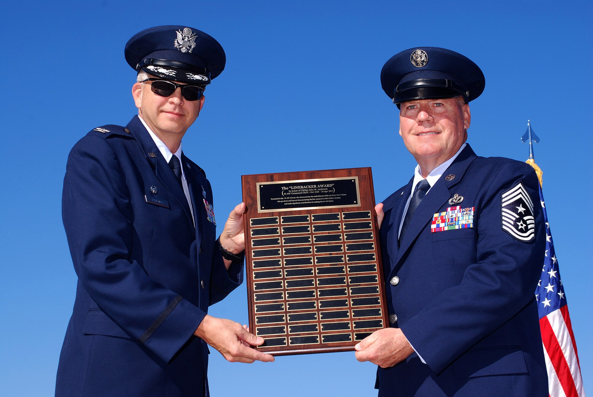 Col. Timothy E. Tarchick, 94th Airlift Wing Commander, displays a new award called the Linebacker Award, named in honor of Chief Master Sgt John M. Anderson, 94th Airlift Wing Command Chief, on the day of his retirement, after 33 years of active and reserve Air Force duty, Apr 3.  The award will be used to recognize exceptional Airman who demonstrate the embodiment of Air Force core values, who go above and beyond in their concern for fellow Airmen and who make significant contributions in making the 94th AW better.   (U.S. Air Force photo/ Brad Fallin)