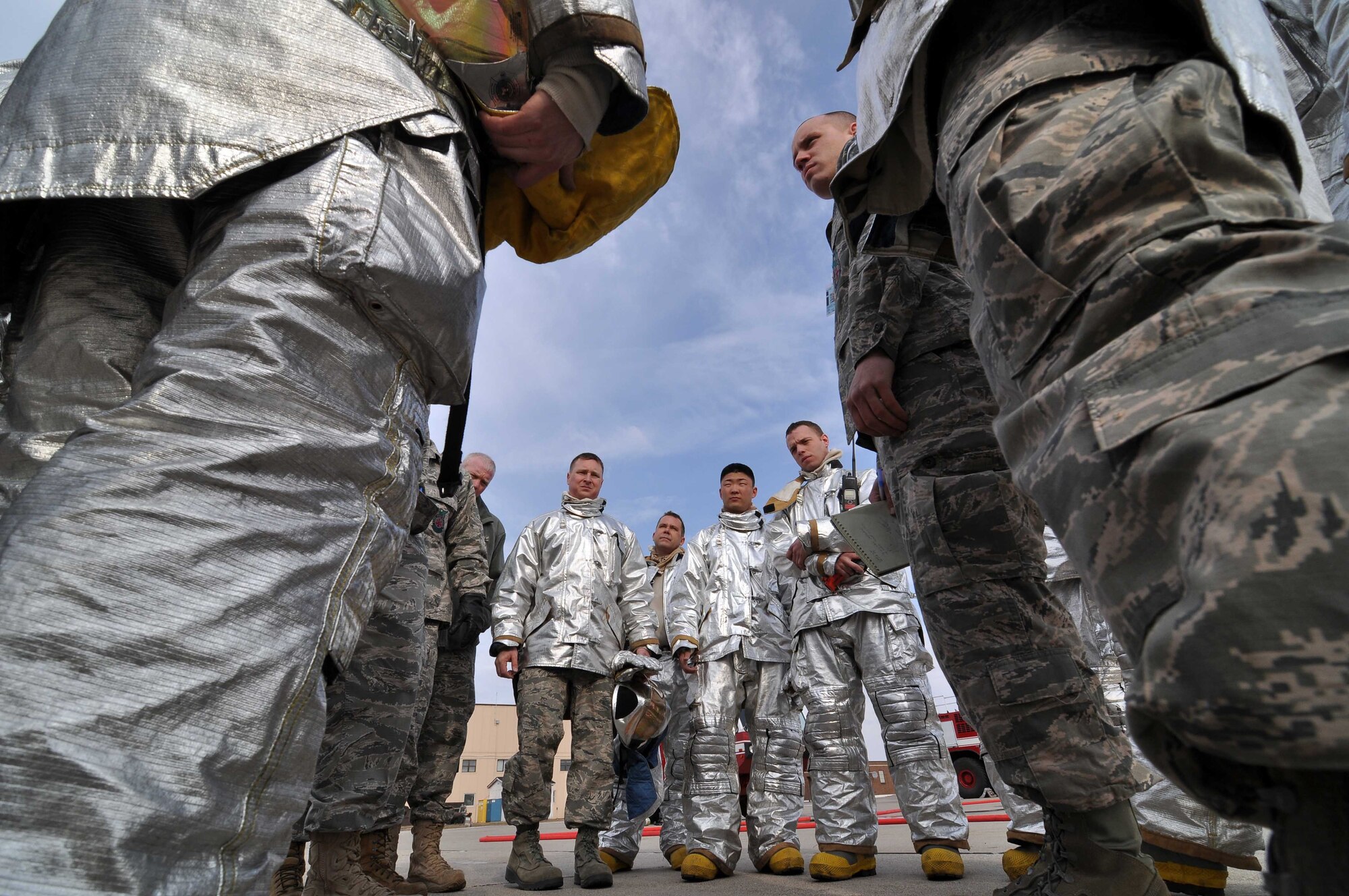 Firefighters from the 934th Airlift Wing, recieve a de-briefing after a simulated C-130 Hercules fire April 3 2011. (Air Force Photo/TSgt Bob Sommer)