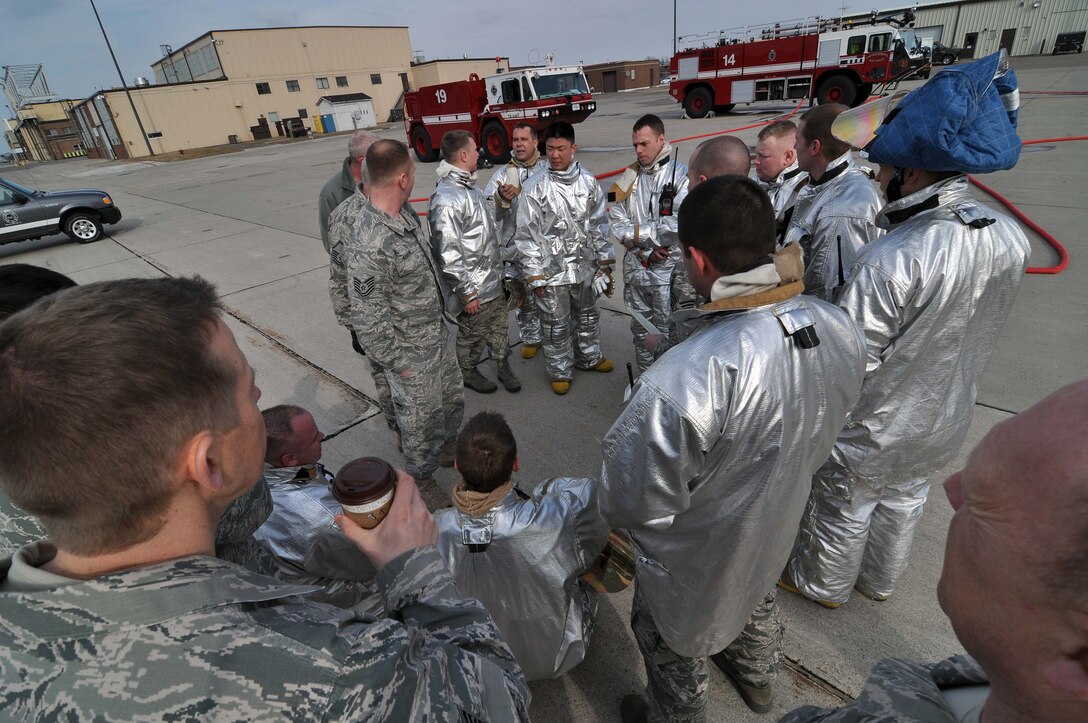 Firefighters from the 934th Airlift Wing, recieve a de-briefing after a simulated C-130 Hercules fire April 3 2011. (Air Force Photo/TSgt Bob Sommer)