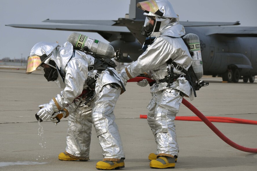 Firefighters from the 934th Airlift Wing, test spray a fire hose during a simulated C-130 Hercules fire April 3 2011. (Air Force Photo/TSgt Bob Sommer)