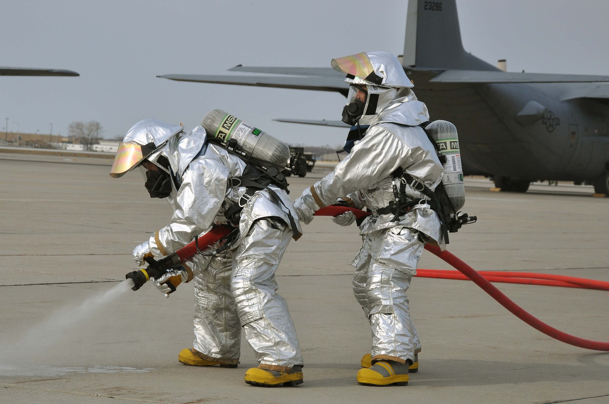 Firefighters from the 934th Airlift Wing, test spray a fire hose during a simulated C-130 Hercules fire April 3 2011. (Air Force Photo/TSgt Bob Sommer)