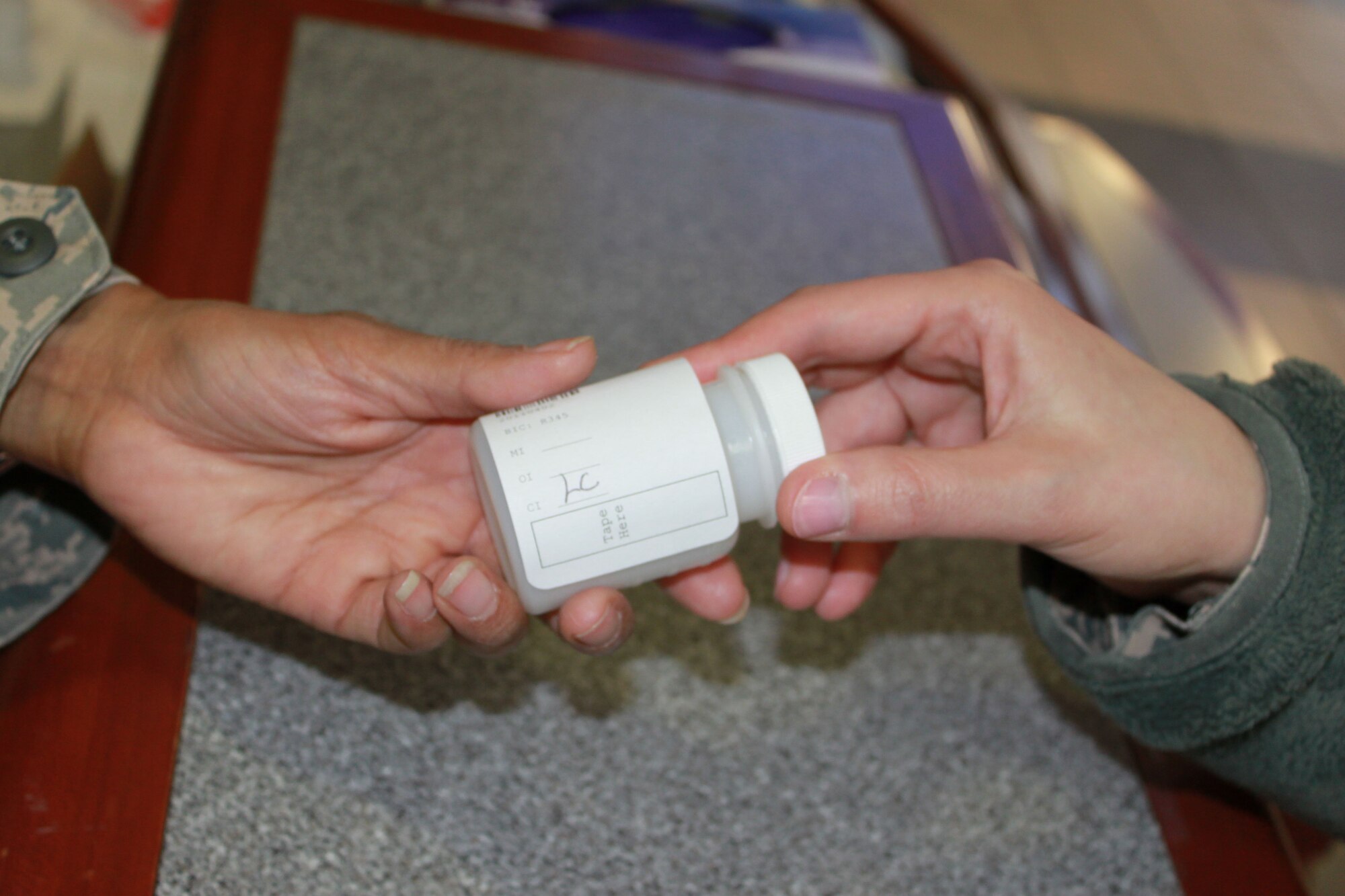 JOINT BASE MCGUIRE-DIX-LAKEHURST, N.J. - A member selected for urinalyis testing receives a specimen bottle. Air Force Reserve Command implemented a new instruction for urinalysis that randomly selects 25 percent of members per month for testing, up from 2 percent with the old policy. Some members may be selected more than once in a given period, while others not at all. (U.S. Air Force photo/Staff Sgt. Monica Dalberg)