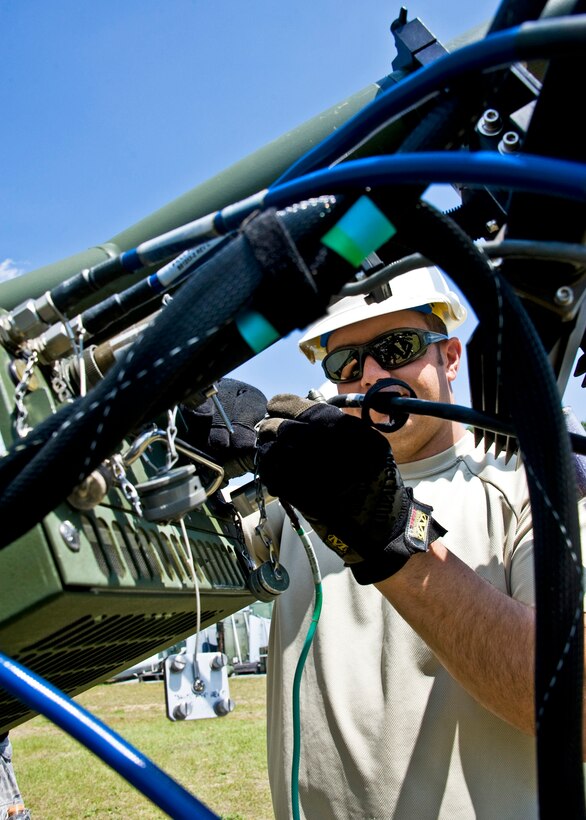 Tech Sgt. Nick Fallecker, 728th Air Control Squadron, connects a cable to the satellite communication terminal at Duke Field April 1 prior to a week-long exercise.  (U.S. Air Force photo/Tech. Sgt. Samuel King Jr.)