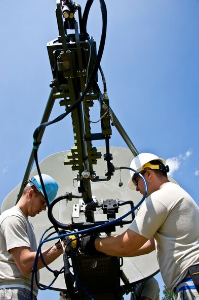 Senior Airman Ryan Adkins and Senior Airman Kristian Ray, 728th Air Control Squadron, set up the satellite communication terminal at Duke Field April 1 prior to a week-long exercise.  (U.S. Air Force photo/Tech. Sgt. Samuel King Jr.)