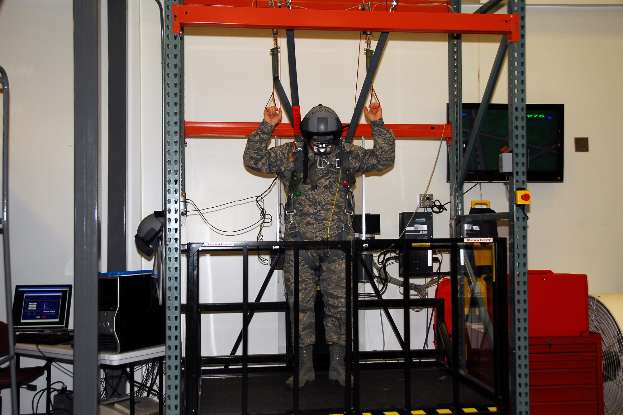 Chief Master Sergeant Steven Larwood, 22nd Air Force command cheif, attempts his landing in the parachute simulator at the 403rd Aircrew Flight Equipment shop. The computer to the left of the photo is where the instructor sets up a scenario and the screne to the right is what Chief Larwood views in his virtual helmet. This is one of the many shops the chief visited at the 403rd Wing's UTA. (U.S. Air Force Photo by Senior Airman Tabitha Dupas)