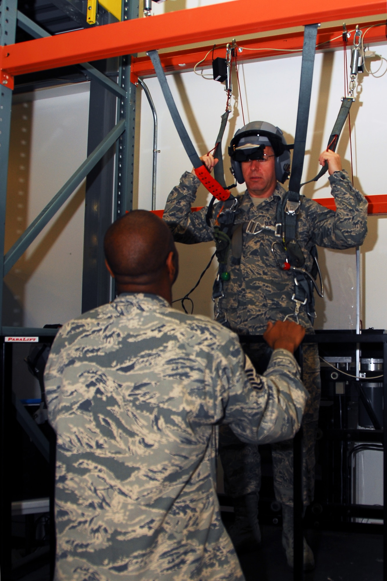 Chief Master Sergeant Steven Larwood, 22nd Air Force command chief, listens to Master Sergeant Ray Reynolds, 403rd Aircrew Flight Equipment supervisor, as he explains how to operate the parachute simulator. On Chief Larwood's visit to the 403rd Wing during April's Unit Training Assembly, he was able to meet with the many Airmen and learn about their individual jobs. (U.S. Air Force Photo by Senior Airman Tabitha Dupas)