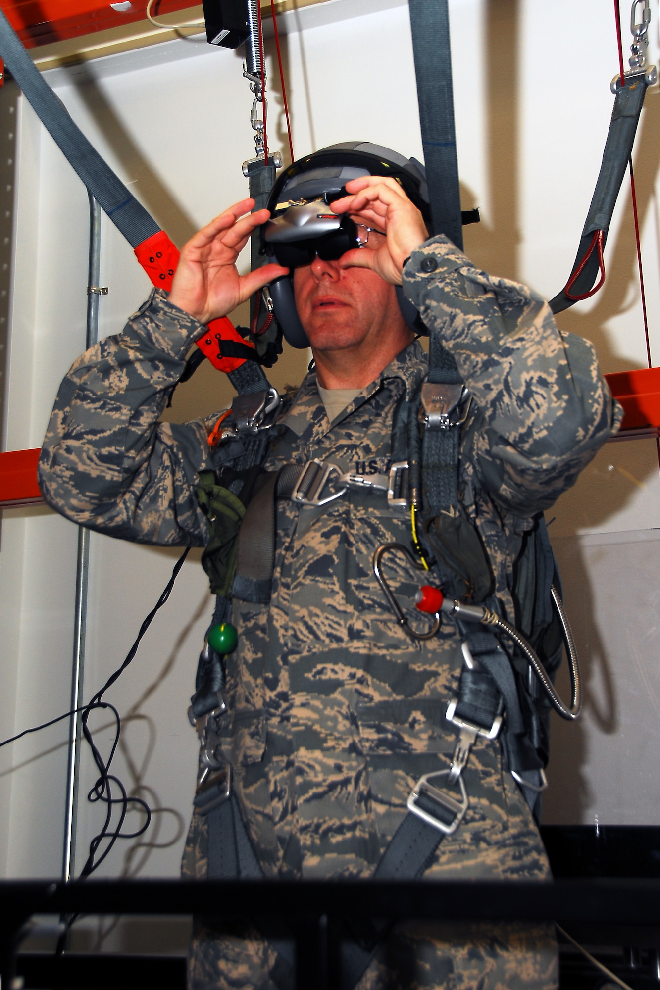 Chief Master Sergeant Steven Larwood, 22nd Air Force command cheif, straps in a parachute simulator and jumps to his virtual destination in the 403rd Aircrew Flight Equipment shop. As part of his job, he makes monthly visits to wings assigned to the 22nd AF to encourage Airmen and listen to their ideas and concerns. (U.S. Air Force Photo by Senior Airman Tabitha Dupas)
