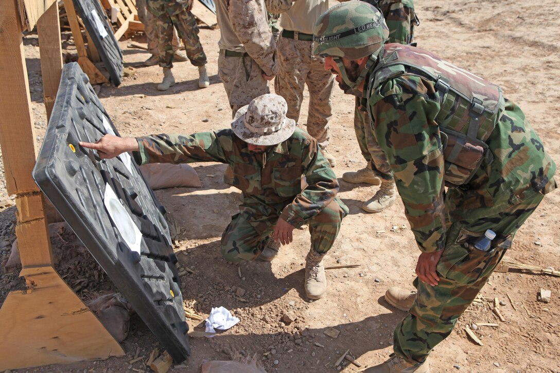 Newly-trained Afghan National Army soldiers review their targets to adjust combat optical scopes during follow-on infantry training at the ANA Academy, Forward Operating Base Geronimo, Helmand province, Afghanistan, April 3. Marines and ANA instructors partner to teach the classes.