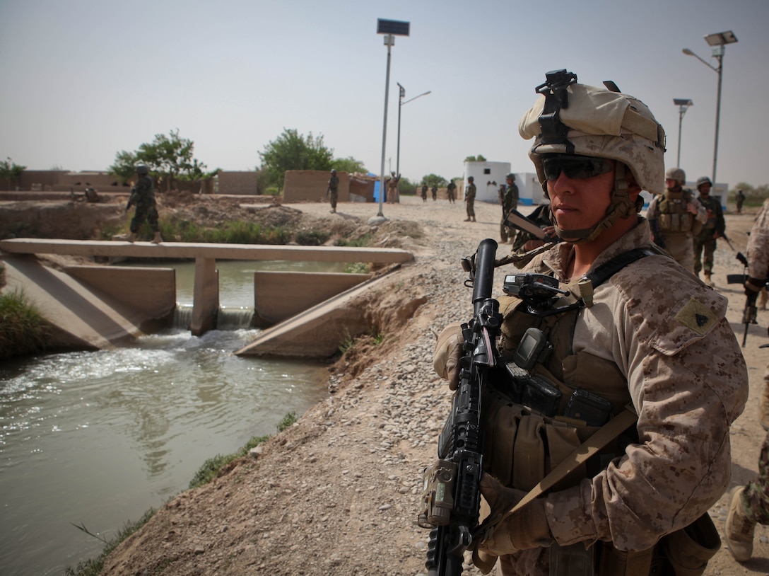 Cpl. Jarrod Knorr, a vehicle commander for 3rd Battalion, 9th Marine Regiment, scans the distance for any sign of threats during a short foot patrol through Marjah district, April 3. The 22-year-old Adrian, Mich., native is currently deployed in support of Operation Enduring Freedom. The PSD provides security for the battalion commander and VIPs visiting the unit’s area of operation, while also building relationships with local citizens when they go out.::r::::n::::r::::n::::r::::n::