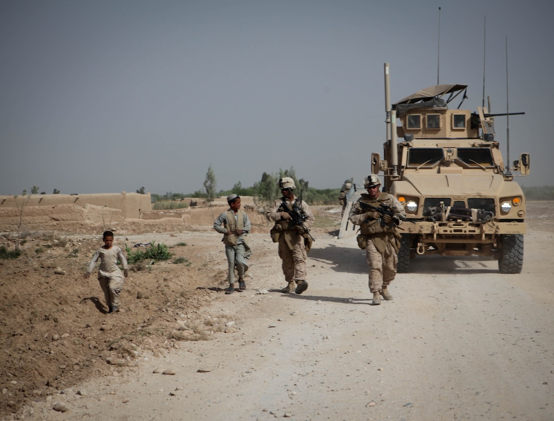 Marines with the Personal Security Detachment patrol outside a combat outpost and interact with Afghan children during a movement through Marjah district, April 3. The PSD for 3rd Battalion, 9th Marine Regiment, Regimental Combat Team 1, is currently deployed in support of Operation Enduring Freedom, providing security for the battalion commander and VIPs visiting the unit’s area of operation, while also building relationships with local citizens when they go out. ::r::::n::::r::::n::::r::::n::