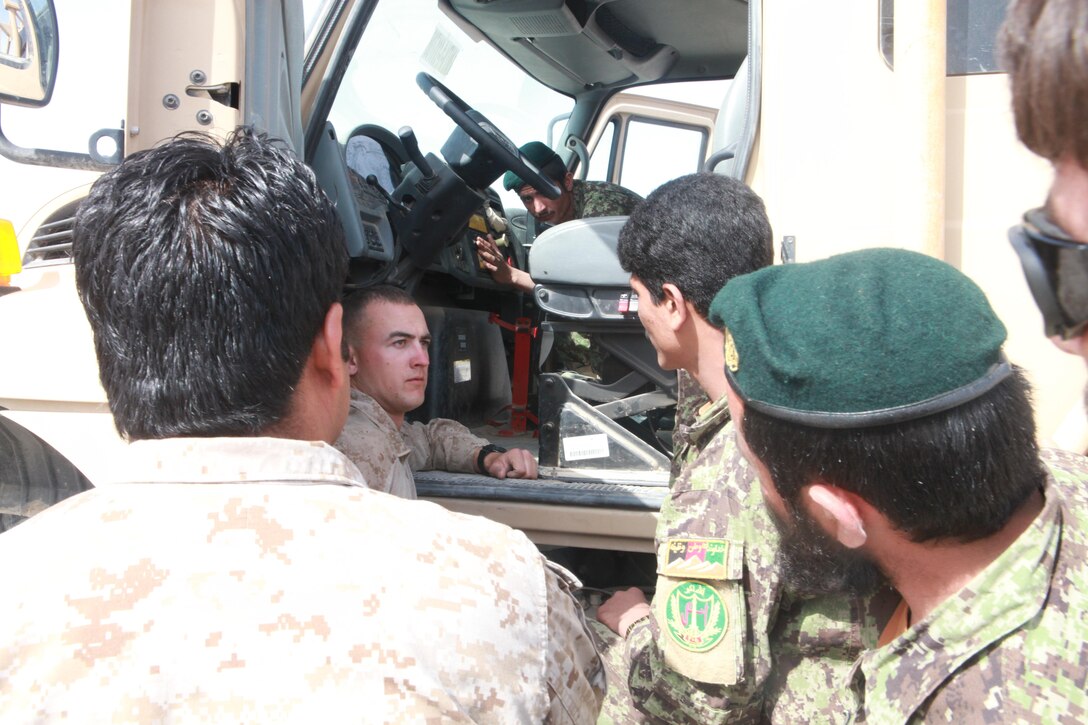 Sarber, Pa., native Cpl. William Betush (left) works through an interpreter to talk with an Afghan National Army soldier about the functions of the truck’s parts. Betush is one of two Marine instructors giving a course on vehicle operation and maintenance. ::r::::n::::r::::n::::r::::n::