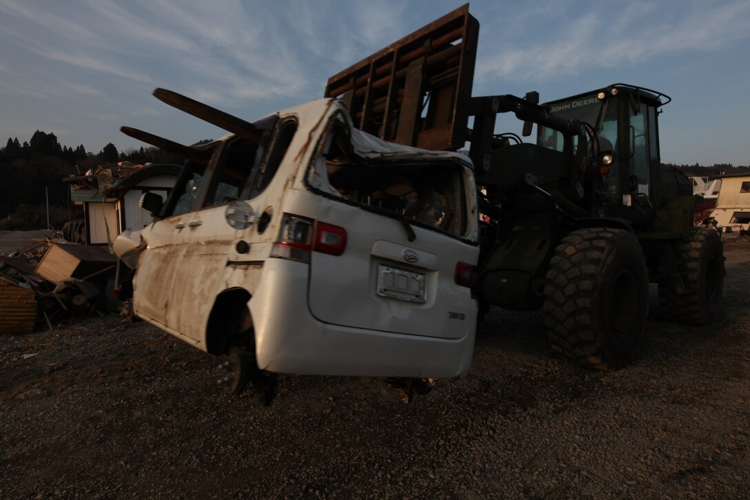 A Tractor, Rubber Tired, Articulated Steering, Multi-Purpose, with Combat Logistics Battalion 31, 31st Marine Expeditionary Unit, moves a damaged car during a humanitarian assistance/disaster relief mission at Uranohama Port, April 1. The mission was in support of Operation Tomodachi.  The 31st MEU's involvement is part of a larger U.S. government response, after a 9.0 earthquake and subsequent tsunami struck Japan causing widespread damage.  The 31st MEU is ready to support our Japanese partners and to provide assistance when called upon.