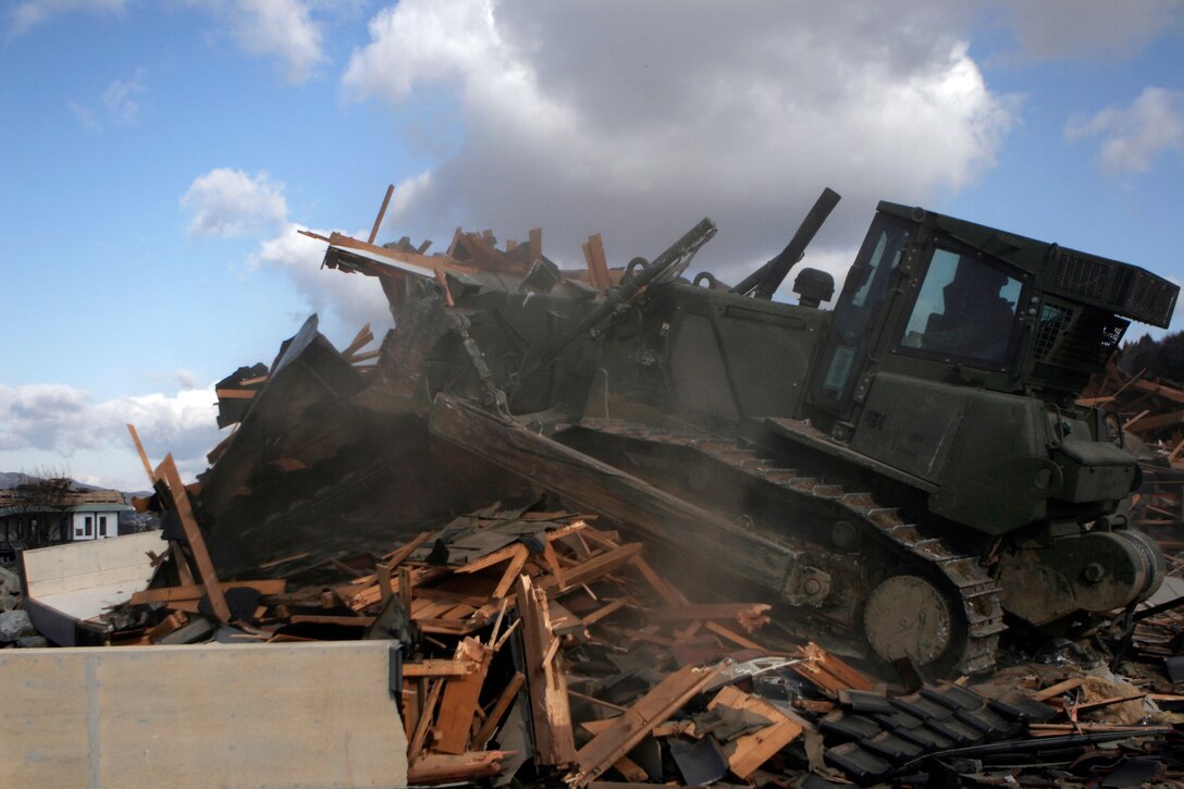 A bulldozer driven by a Marine with the Battalion Landing Team, 2nd Battalion, 5th Marines, 31st Marine Expeditionary Unit, breaks a destroyed house into smaller pieces and moves it off a road, April 4. As part of Operation Tomodachi, the 31st MEU is ready to support our Japanese partners and to provide assistance when called upon.