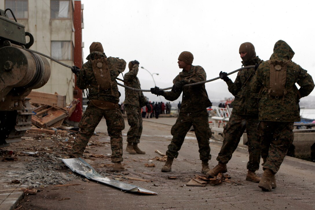 Marines with Battalion Landing Team 2nd Battalion, 5th Marines, 31st Marine Expeditionary Unit, pull a cable from the winch of a bulldozer, April 4. The Marines were in the process of tearing down a house damaged beyond repair, making it safer for the locals, and allowing more access to the port. As part of Operation Tomodachi, the 31st MEU is ready to support our Japanese partners and to provide assistance when called upon.