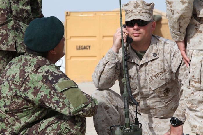 Staff Sgt. Richard Near, a radio operator with the Embedded Partnering Team, Combat Logistics Battalion 8, 2nd Marine Logistics Group (Forward), shows soldiers from the 5th Kandak of the Afghan National Army how to use a radio during a course at Forward Operating Base Delaram, Afghanistan, April 4, 2011. The month-long course covered setting up radios, troubleshooting them and proper radio etiquette.