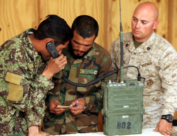 Staff Sgt. Richard Near, a radio operator course instructor with the Embedded Partnering Team, Combat Logistics Battalion 8, 2nd Marine Logistics Group (Forward), helps two Afghan National Army soldiers from the 5th Kandak communicate with other soldiers via radio during a course at Forward Operating Base Delaram, Afghanistan, April 4, 2011.  Twelve ANA soldiers graduated from the latest radio operator course during a ceremony at FOB Delaram June 5, 2011.  The course consisted of 54 hours of classroom instruction and 28 hours of practical application.  The soldiers learned the different components and capabilities, as well as how to set up and program the PRC-1077 VHF radio and the RT-7000 HF radio.