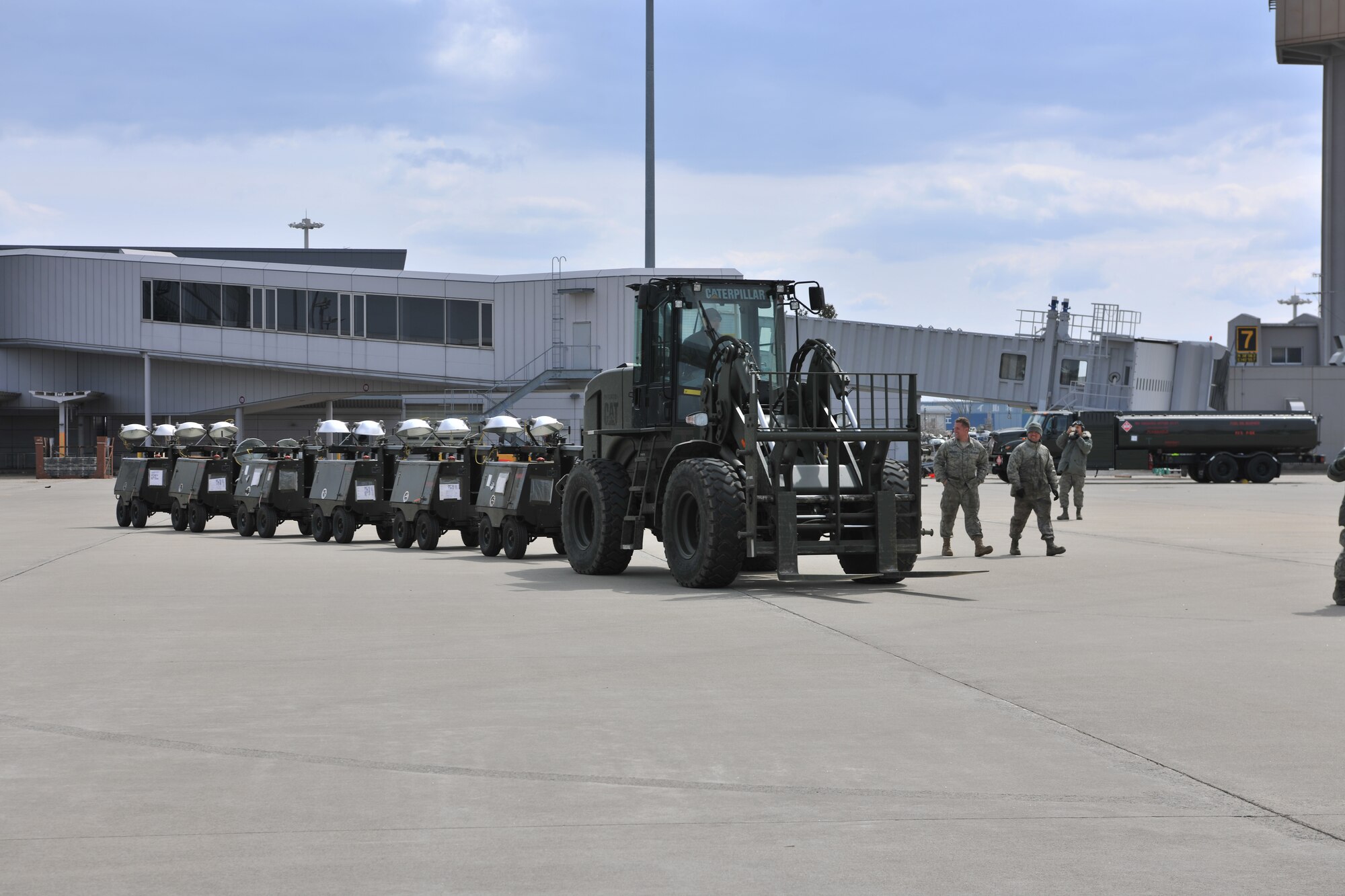 SENDAI AIRPORT, Japan -- Members from the 374th Logistics Readiness Squadron from Yokota Air Base deliver flood lights to an MC-130P Combat Shadow aircraft at Sendai Airport April 3. U.S. forces have assisted the Japanese with relief efforts following the earthquake and tsunami that struck March 11. (U.S. Air Force photo/Master Sgt. Kimberly Spinner)
