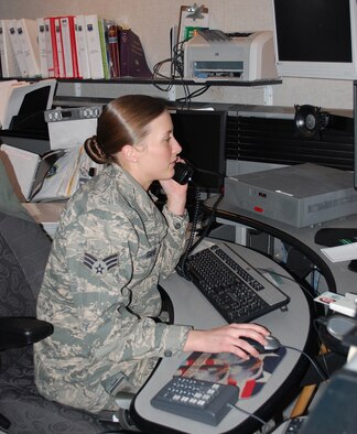 Senior Airman Tonya Saenz, 341st Security Forces Squadron Base Defense Operations Center controller, looks up information for a customer on the phone March 24. (U.S. Air Force photo/Valerie Mullett)