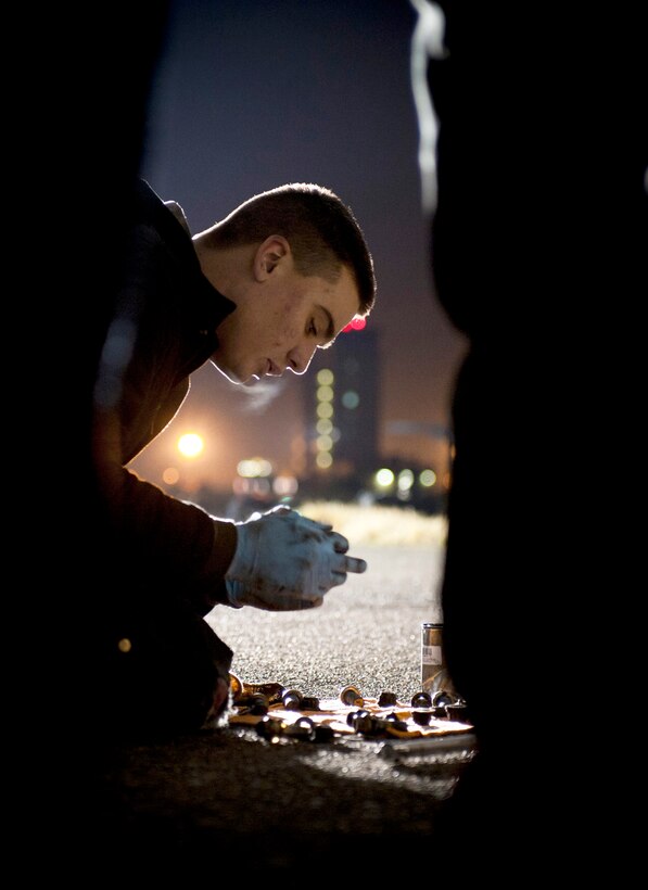 Airman 1st Class Stephen Tessier applies grease to bolts for a C-130 Hercules March 31, 2011, at Yokota, Japan. Tessier is a crew chief assigned to the 374th Maintenance Squadron. (U.S. Air Force photo/Staff Sgt. Chad C. Strohmeyer)