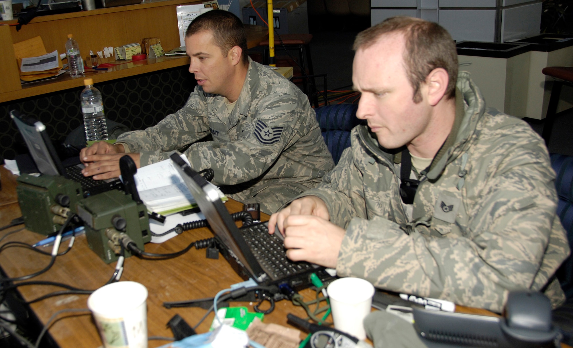 Tech. Sgt. Denis Bryant (left) and Staff Sgt. Chris Sefton review aircraft landing schedules here March 29, 2011, at Sendai Airport, Japan. A team of 20 Airmen deployed there to help the Japanese recover and rebuild in the wake of the March 11 earthquake and tsunami. Bryant is an air transportation craftsman from Hickam Air Force Base, Hawaii; Sefton is a ground radio technician from Kadena Air Base, Japan. (U.S. Air Force Photo/ Staff Sgt. J.G. Buzanowski)