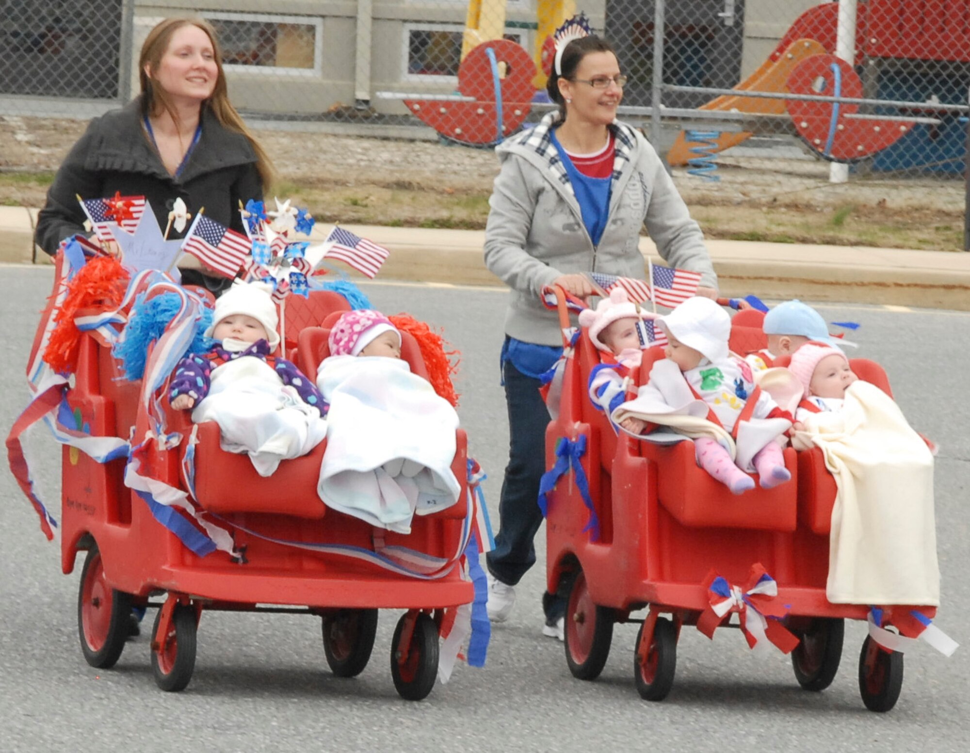 Stephanie Marsters (left) and Maria Rogers, 436th Force Support Squadron Child/Youth Program assistants, push children from the Child Development Center during the Month of the Military Child parade April 1, 2011, at Dover Air Force Base, Del. The Month of the Military Child was established to honor the military children for their heroism, character, courage, sacrifices and continued resilience. (U.S. Air Force photo by Airman 1st Class Matthew Hubby)