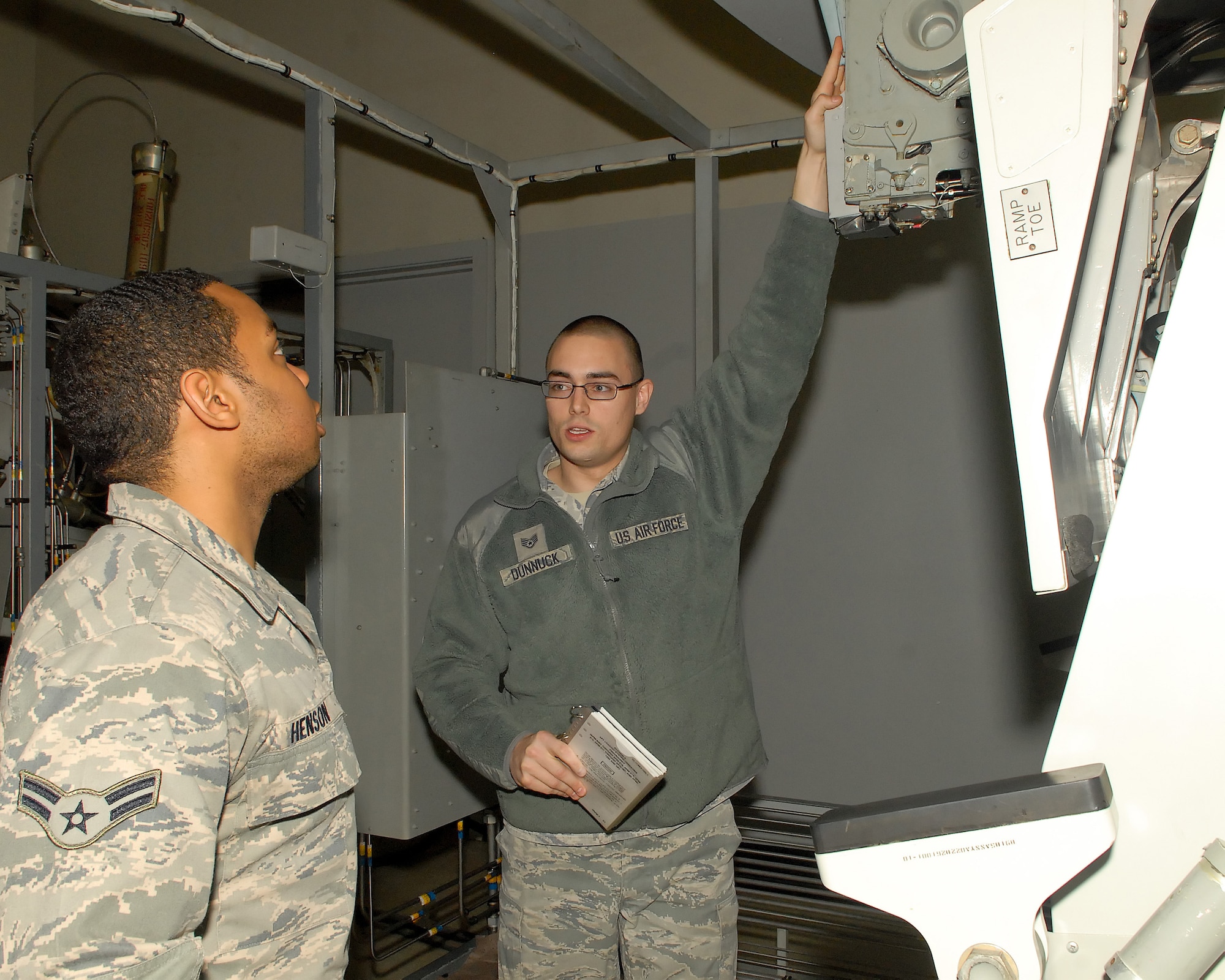 Staff Sgt. Anthony Dunnuck drills Airman 1st Class Raphael Henson on maintenance procedures using the training simulator at Building 206 at Dover Air Force Base, Del. The training simulator is used when no real plane is available due to mission constraints. Sergeant Dunnuck is a Maintenance Qualification Training Program instructor with the 436th Maintenance Operations Squadron and Airman Henson is a maintenance apprentice with the 436th Maintenance Squadron.  (U.S. Air Force photo by Airman 1st Class Samuel Taylor)