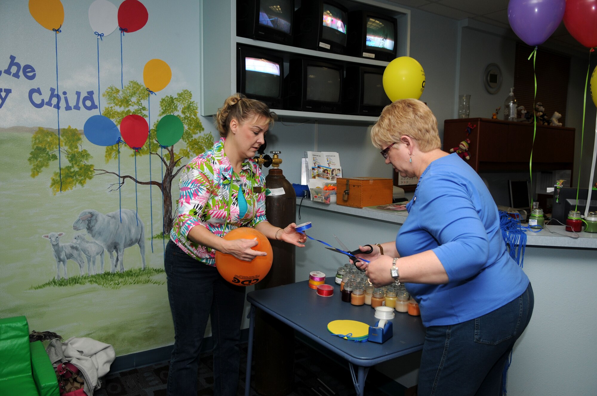GOODFELLOW AIR FORCE BASE – (left to right) Dennisse Jones, Director of the Child Development Center, and Marilyn Stewart, Assistant  Director of the CDC,  prepare balloons and candles to hand out as parents drop off their children, April 1. The Proud of my Military Child Day event kicks off April’s Month of the Military Child. (U.S. Air Force photo/Staff Sgt. Heather Rodgers)