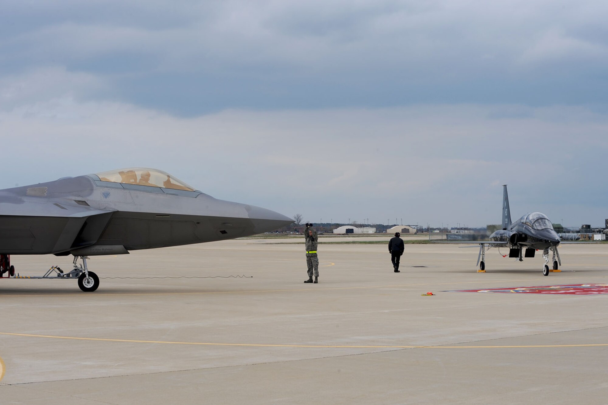 Col. Matthew Molloy, 1st Fighter Wing commander, taxis an F-22 Raptor onto Langley Air Force Base, Va., April 1 with Col. Kevin Mastin, 1 FW vice commander, following in a T-38 Talon. The T-38, from Holloman AFB, N.M., is TDY here for six months to help train 1st FW pilots and prepare them for when it is permanently stationed here. (U.S. Air Force photo/Staff Sgt. Ashley Hawkins/Released) 