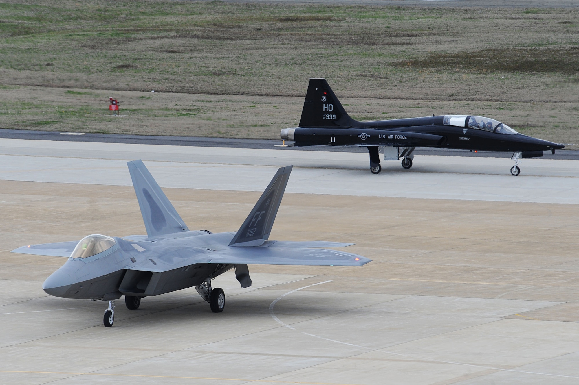 An F-22 Raptor and a T-38 Talon arrive at Langley Air Force Base, Va., April 1, 2011. The T-38 is temporarily assigned to the 1st Fighter Wing to support combat readiness training for the pilots. (U.S. Air Force photo by Senior Airman Brian Ybarbo/Released)

