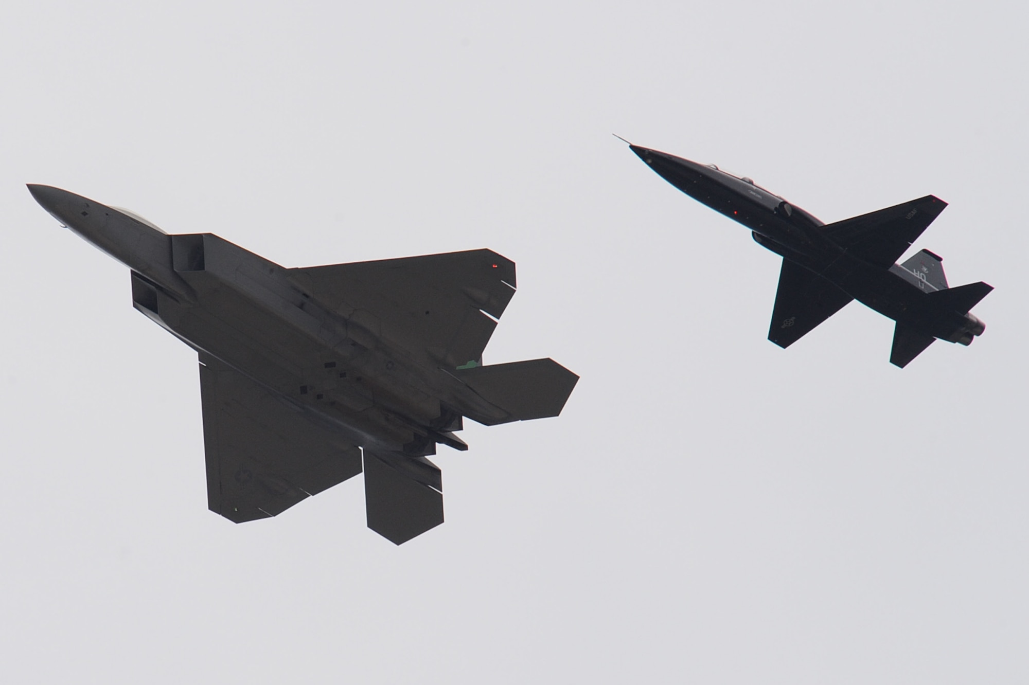 An F-22 Raptor escorts a T-38 Talon onto Langley Air Force Base, Va., April 1, 2011. The T-38 Talon, flown by Col. Kevin Mastin, 1st Fighter Wing vice commander, is on a temporary assignment to support the F-22 Raptors and provide hands-on combat readiness training for 1st FW pilots. (U.S. Air Force photo by Senior Airman Brian Ybarbo/Released)

   