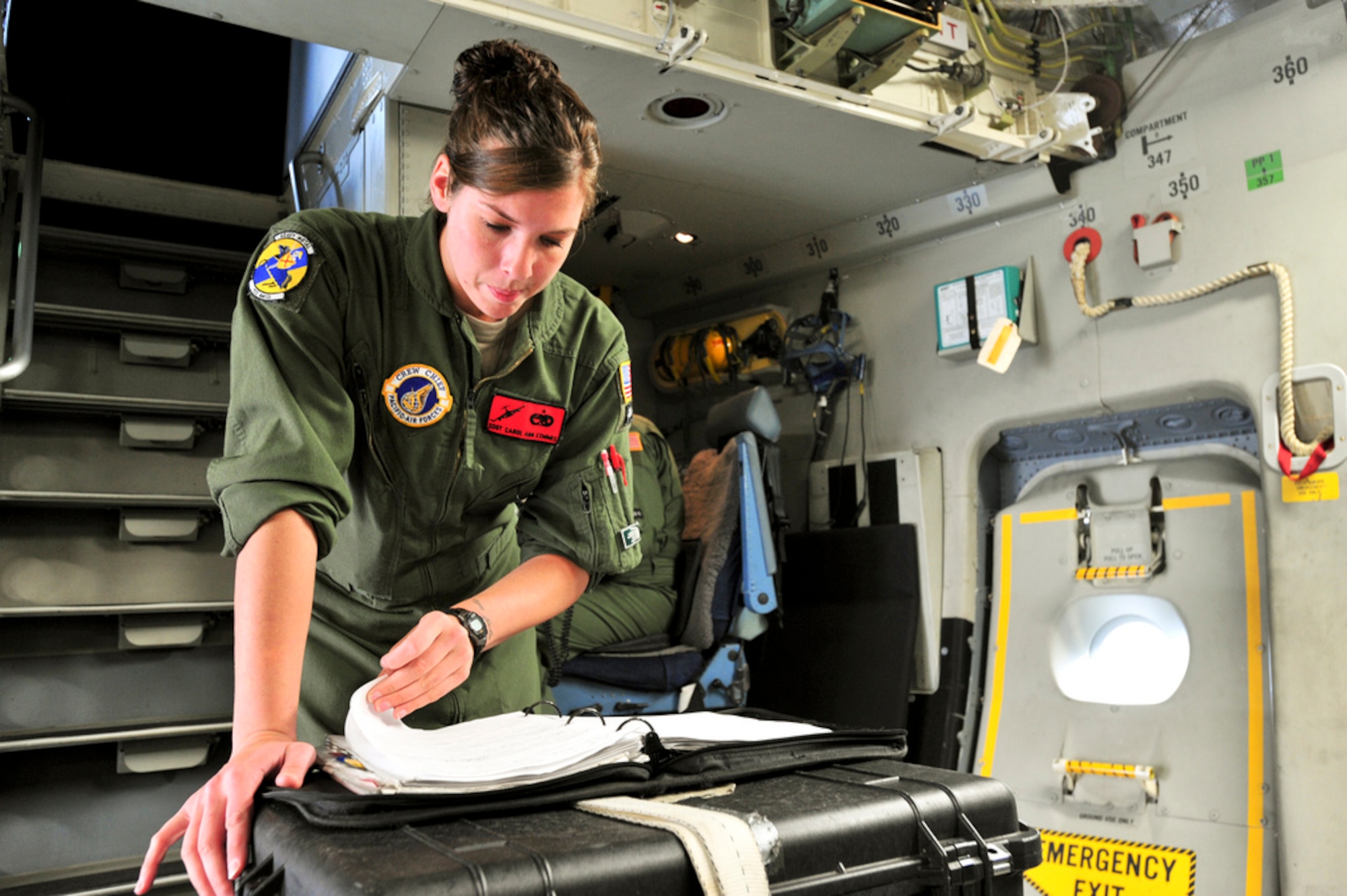 YOKOTA AIR BASE, Japan -- Staff Sgt. Carol Ann Kemmis, a flight crew chief with the 703rd Aircraft Maintenance Squadron, goes over the maintenance logs of a C-17 Globemaster III prior to a mission here, April 2. Sergeant Kemmis and members of the 517th Airlift Squadron from Joint Base Elmendorf-Richardson, Alaska are providing support to Operation Tomodachi by shuttling supplies to and from other bases around Japan. (U.S. Air Force Photo/ Staff Sgt. Joshua Garcia)