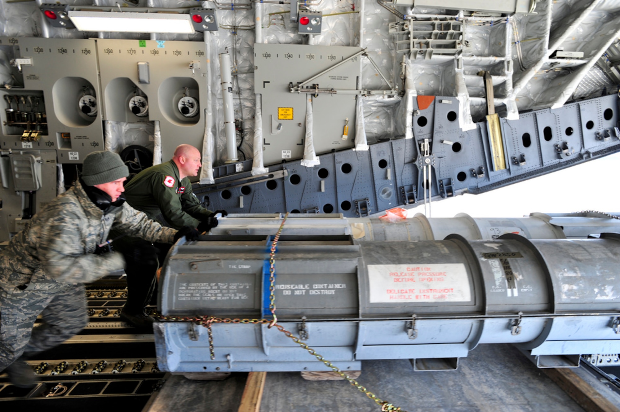 MISAWA AIR BASE, Japan -- Staff Sgt Christopher Wilkinson, 621st Contingency Responce Wing, and Technical Sgt. Travis Duxsbury, a loadmaster with the 517th Airlift Squadron, offload cargo here, April 1. (U.S. Air Force Photo/ Staff Sgt. Joshua Garcia)