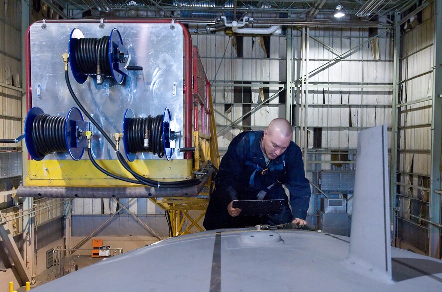 Staff Sgt. Steven Mills, 436th Maintenance Squadron aircraft-fuel-systems technician, reinstalls a panel on the top of a C-17 to secure a new universal aerial refueling receptacle slipway installation March 29, 2011, at Dover Air Force Base, Del. (U.S. Air Force photo by Roland Balik)